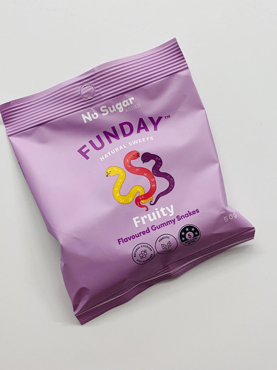 Purple package of Funday gummy snakes on a light gray background