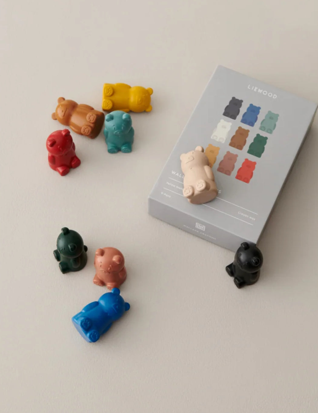 A set of small bear-shaped cayons in multiple colors arranged around a gray product box labeled LIEWOOD on a light beige background.
